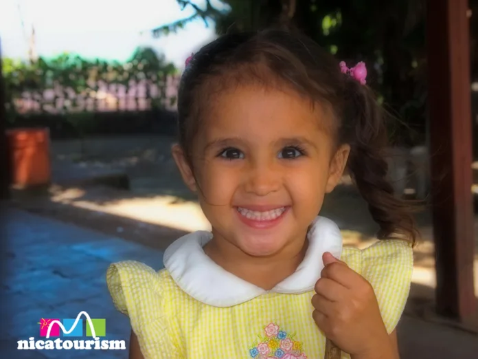 OLYMPUS DIGITAL CAMERA Niña de Nicaragua, feliz con un juguete