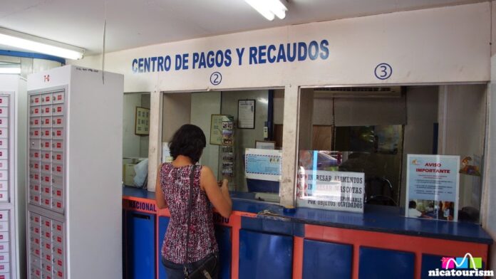 Centro Comercial post office in Managua A woman paying for postage at a Nicaraguan post office